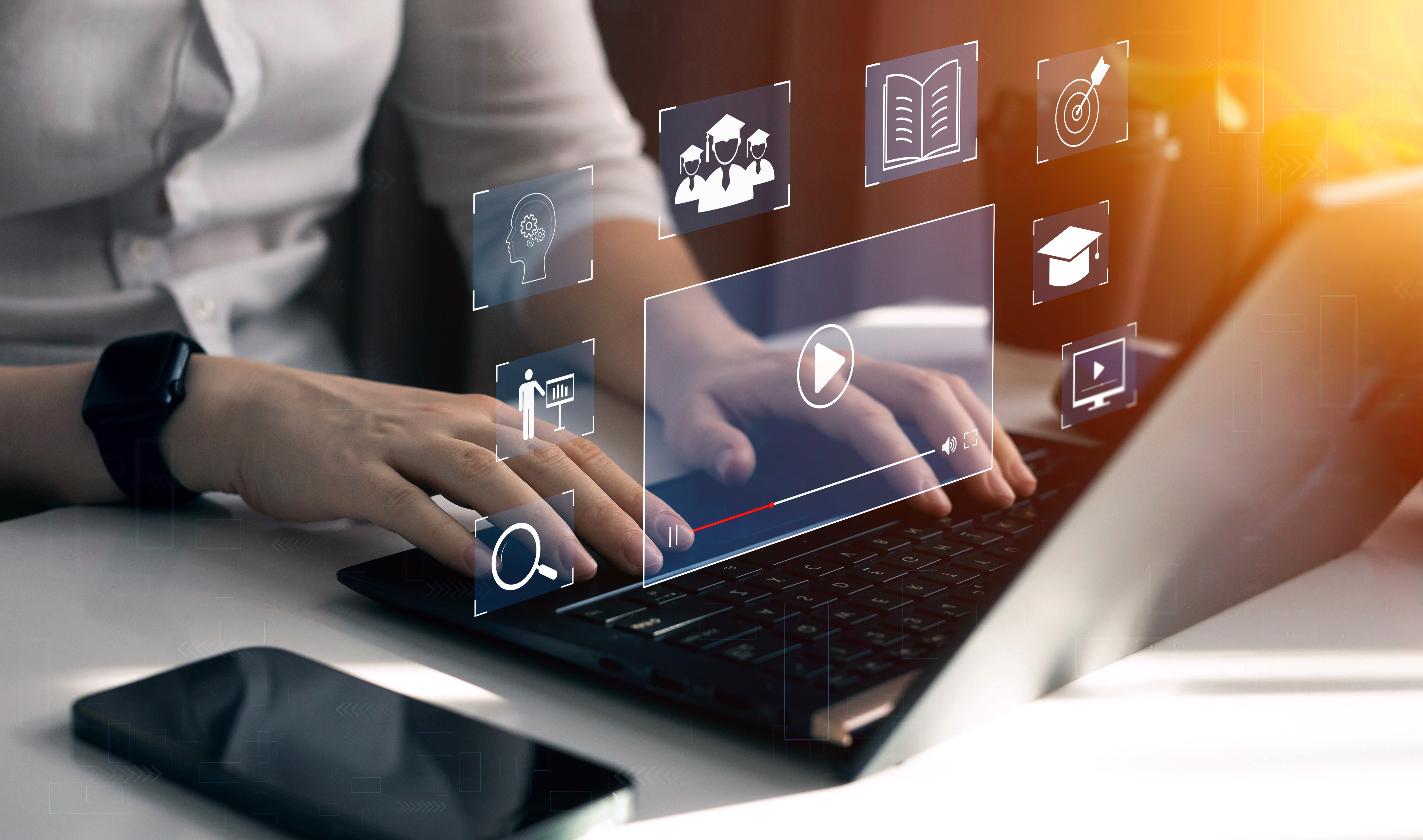 Eine Person sitzt am Laptop und durch ein Hologramm wird ersichtlich, welche Online-Unterweisungs-Funktionen genutzt werden.