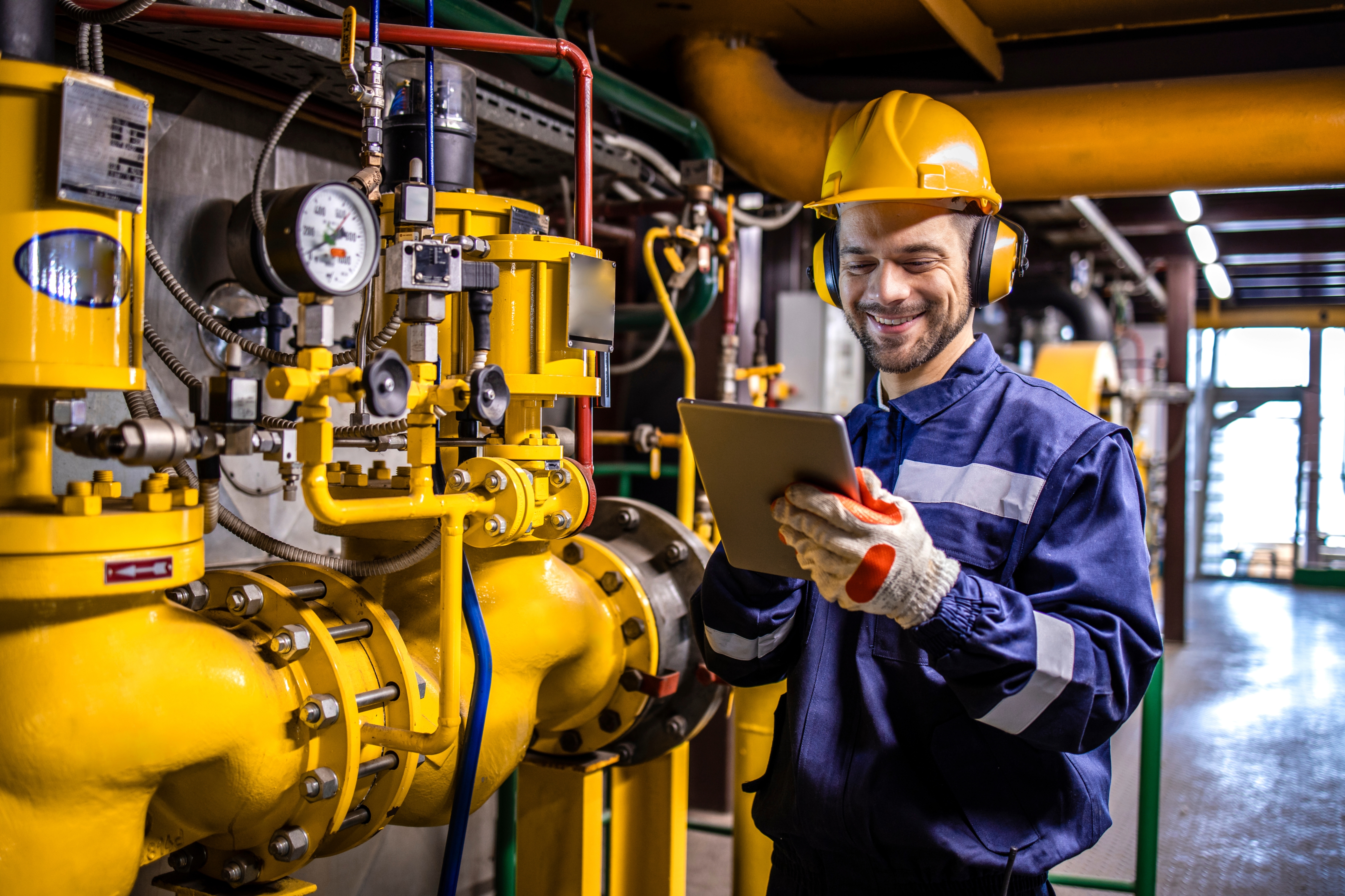 Ein Mann in Schutzausrüstung, der mit einem Tablet etwas überprüft.